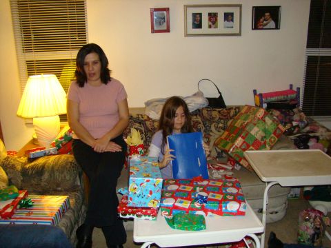 1989 Ford Bronco - A woman and a young girl are seated on a couch surrounded by wrapped presents, seemingly during a holiday gift-opening event.