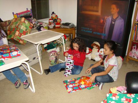 1989 Ford Bronco - Children unwrap gifts on the floor in front of a television displaying a movie scene.