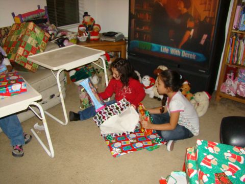 1989 Ford Bronco - Children excitedly unwrap gifts on Christmas morning in a room filled with toys and holiday decorations.