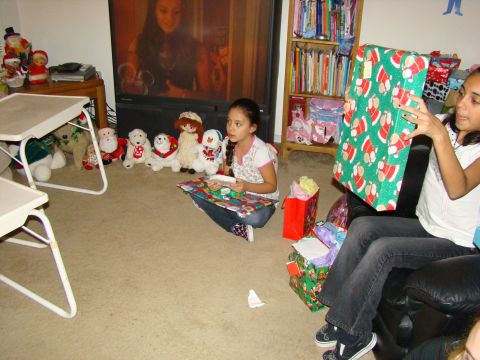 1989 Ford Bronco - Children opening presents during a Christmas celebration, with toys and a TV in the background.