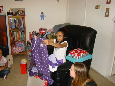 1989 Ford Bronco - A young girl unwraps a gift of purple pajamas while sitting in a chair surrounded by presents.