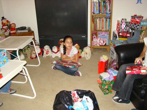 1989 Ford Bronco - A young girl sits on the floor on Christmas morning, surrounded by gifts and stuffed animals.