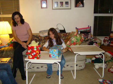 1989 Ford Bronco - A festive Christmas scene unfolds as a young girl eagerly opens a gift, while a woman watches with a smile.