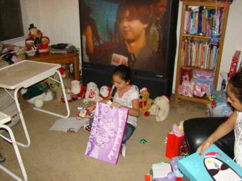 1989 Ford Bronco - Children excitedly open presents on Christmas morning, surrounded by holiday decorations and stuffed animals.