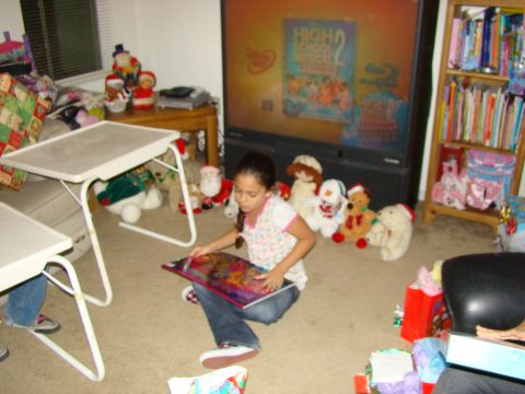 1989 Ford Bronco - A young girl sits on the floor reading a book amidst a collection of stuffed animals and holiday decorations in a living room.