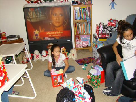 1989 Ford Bronco - Children are opening Christmas presents in a living room, with a TV displaying Adrienne Bailon.