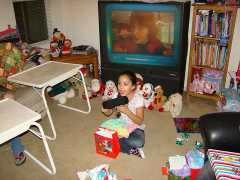 1989 Ford Bronco - A girl sits on the floor surrounded by gifts and stuffed animals, watching television.