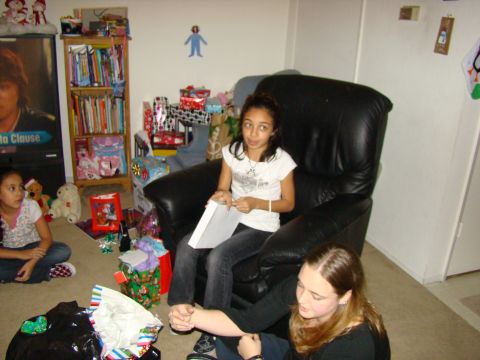 1989 Ford Bronco - A holiday scene with people and gifts, possibly Christmas, in a room with a large poster on the wall.