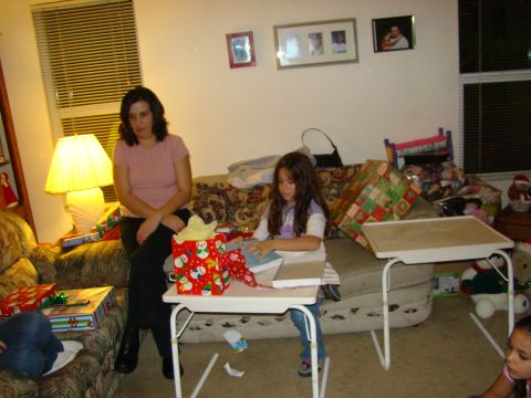 1989 Ford Bronco - A family gathers in a living room decorated for Christmas, with gifts piled around.