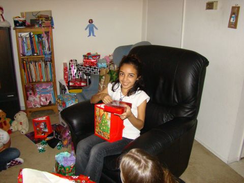 1989 Ford Bronco - A young girl smiles as she opens a Christmas gift surrounded by presents and decorations.