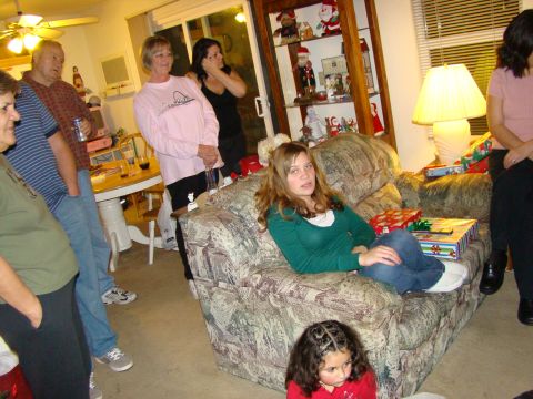 1989 Ford Bronco - A group of people are gathered in a living room, with gifts visible and decorations on a shelf.