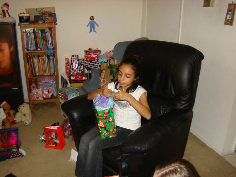 1989 Ford Bronco - A young girl opens a gift bag filled with tissue paper while surrounded by Christmas presents.