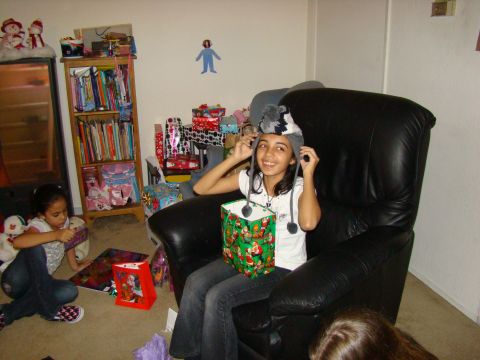 1989 Ford Bronco - Two young girls are opening presents in a living room, one wearing a festive hat.