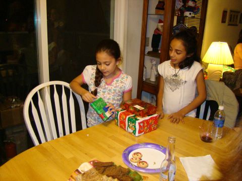 1989 Ford Bronco - Two young girls are excitedly opening gifts on Christmas, gathered around a wooden table with cookies and drinks.
