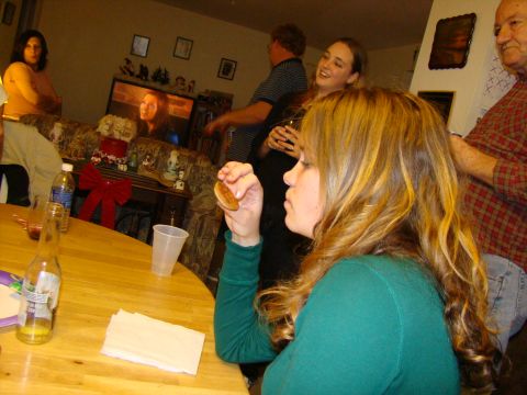 1989 Ford Bronco - A group of people are enjoying a holiday gathering, with a woman in the foreground holding a small food item.
