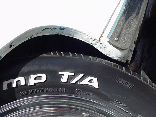BFGoodrich Radial T/A 225/60HR14 tire on chrome wheel under a peeling green fender lip