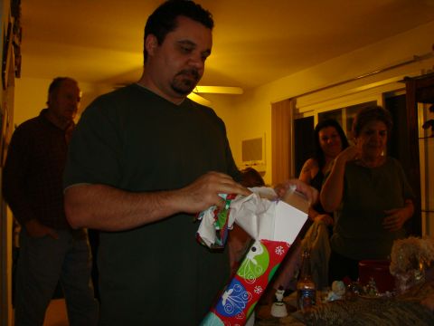 1989 Ford Bronco - A group of people are gathered indoors, with one man opening a Christmas stocking.
