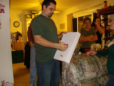 1989 Ford Bronco - A man holds a white box while others watch in a warmly lit room.