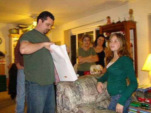 1989 Ford Bronco - A group of people are gathered indoors, seemingly opening gifts during a holiday celebration.