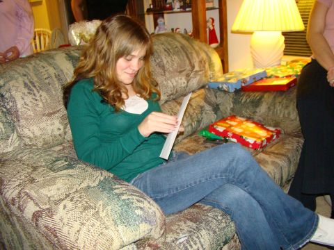 1989 Ford Bronco - A woman opens a card while sitting on a couch surrounded by wrapped gifts.