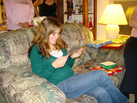 1989 Ford Bronco - A woman smiles while reading a card on a couch surrounded by wrapped gifts.