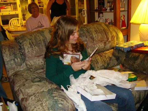 1989 Ford Bronco - A young woman opens a gift while sitting on a couch, with others in the room.