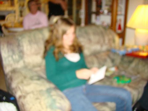 1989 Ford Bronco - A young woman sits on a patterned couch, engrossed in a piece of paper, while others are visible in the background.