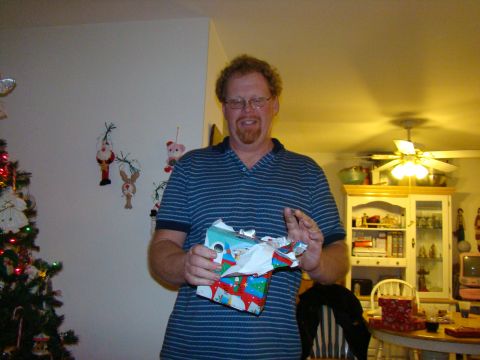 1989 Ford Bronco - Man opening a Christmas present in a room decorated for the holidays.