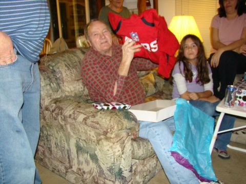 1989 Ford Bronco - A man receives a gift, possibly a sports jersey, while sitting with family during a gathering.