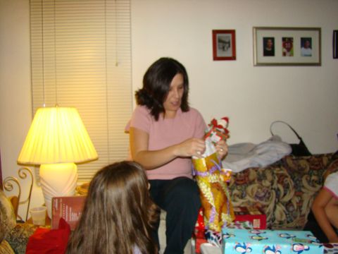 1989 Ford Bronco - A woman unwraps a gift in a living room setting, with a child and other presents visible.