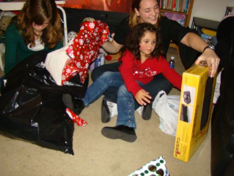 1989 Ford Bronco - A group of people are gathered on the floor, engaged in opening presents during what appears to be a holiday celebration.