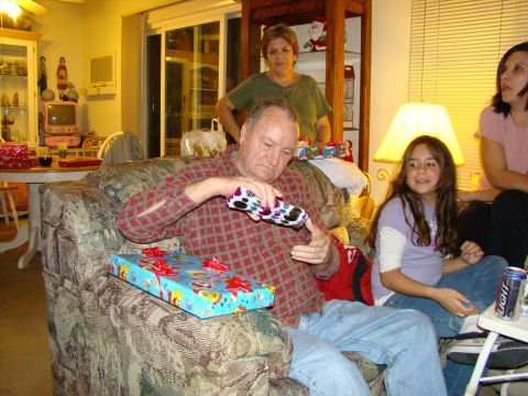 1989 Ford Bronco - A family gathers to open Christmas gifts, with a man in the foreground examining a present.