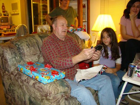 1989 Ford Bronco - A family gathers to open presents, with a man in the foreground examining a gift.