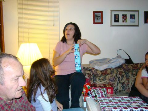 1989 Ford Bronco - A group of people are gathered in a living room, with one woman opening a present.