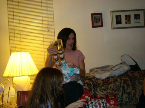 1989 Ford Bronco - A woman excitedly opens a gift, revealing a set of small bottles, while another person watches.