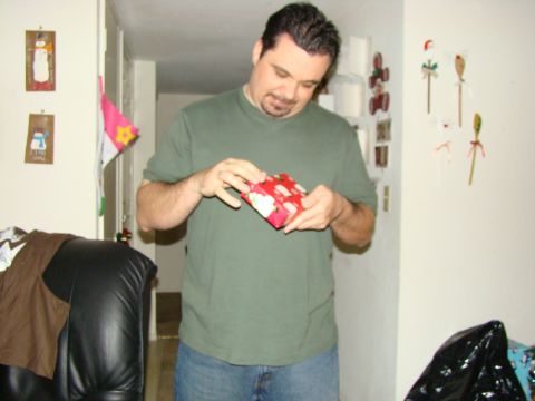 1989 Ford Bronco - Man unwraps a Christmas present indoors, with holiday decorations visible.
