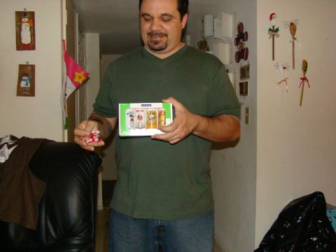 1989 Ford Bronco - A man holds a gift box containing miniature bottles of alcohol and a small red item.