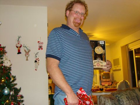 1989 Ford Bronco - A man proudly displays a Jim Beam BBQ set during a holiday gathering, with festive decorations in the background.