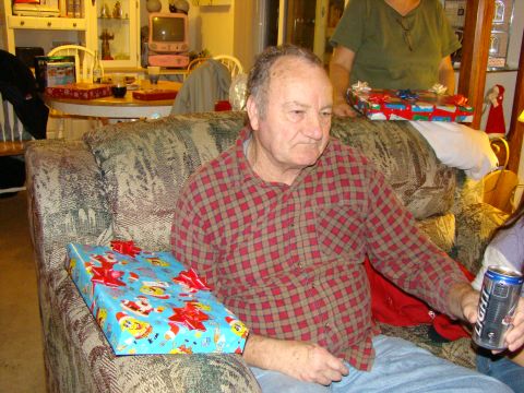 1989 Ford Bronco - Man sits on a couch surrounded by Christmas presents, holding a can of beer.