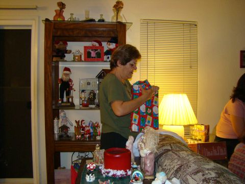 1989 Ford Bronco - A woman unwraps a Christmas gift in a room decorated with holiday items.
