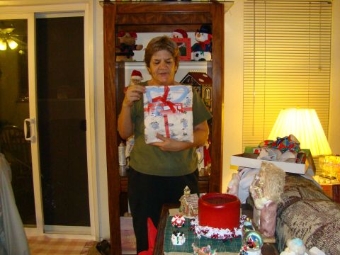 1989 Ford Bronco - A woman presents a gift, surrounded by festive decorations and furniture in a home setting.