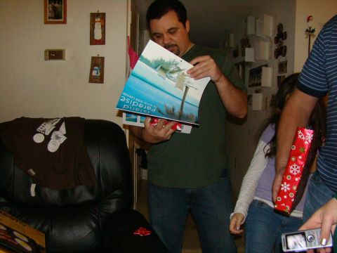 1989 Ford Bronco - A group of people are opening gifts, with one person holding up a calendar that shows 'Island Paradise' on its cover.