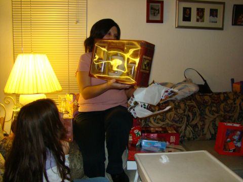 1989 Ford Bronco - A woman is holding a gift box while a child watches. Presents are visible around the room.