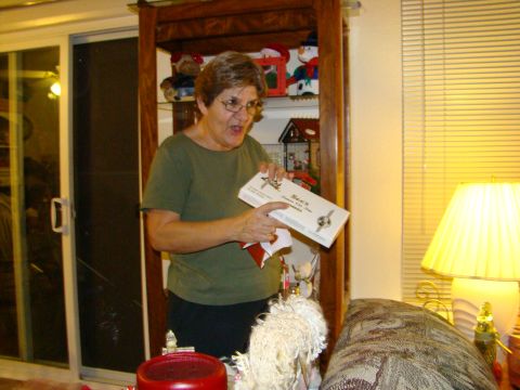 1989 Ford Bronco - A woman excitedly holds a box of See's Candies during a holiday gathering.