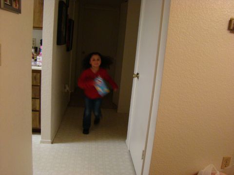 1989 Ford Bronco - A young girl runs down a hallway, holding an item. The scene appears to be indoors.