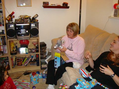 1989 Ford Bronco - A group of people are gathered in a living room, opening presents.