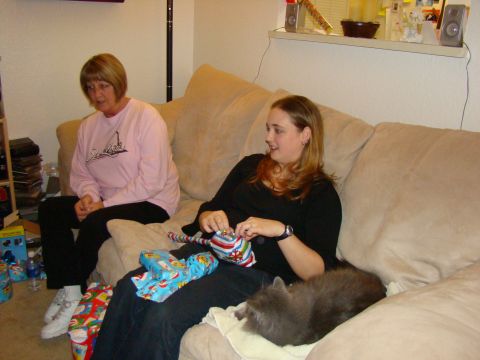 1989 Ford Bronco - Two women and a cat relax on a couch surrounded by wrapped gifts.