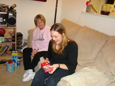 1989 Ford Bronco - Two women are sitting on a couch, one opening a gift with excitement.