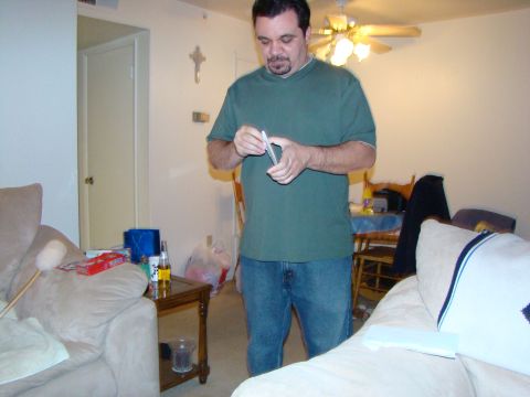 1989 Ford Bronco - Man holding a card in a room with furniture and a ceiling fan.