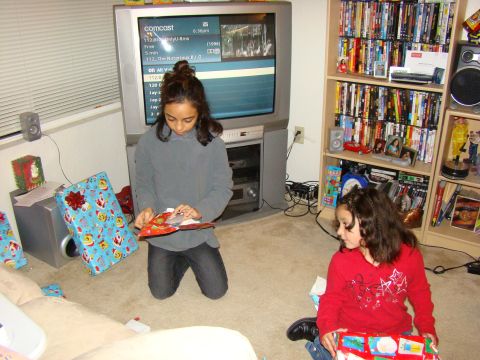 1989 Ford Bronco - Two young girls are opening gifts on Christmas morning in a living room.